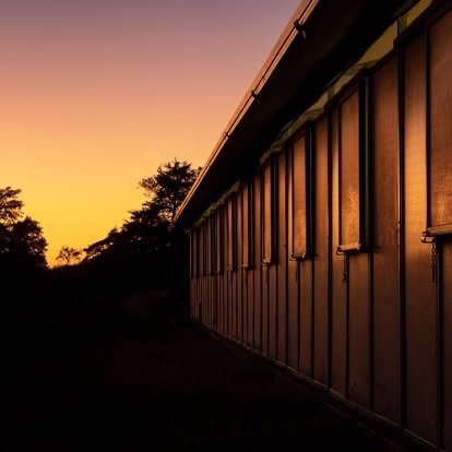 Deleu Ranch barn silhouetted against a golden Texas sunset